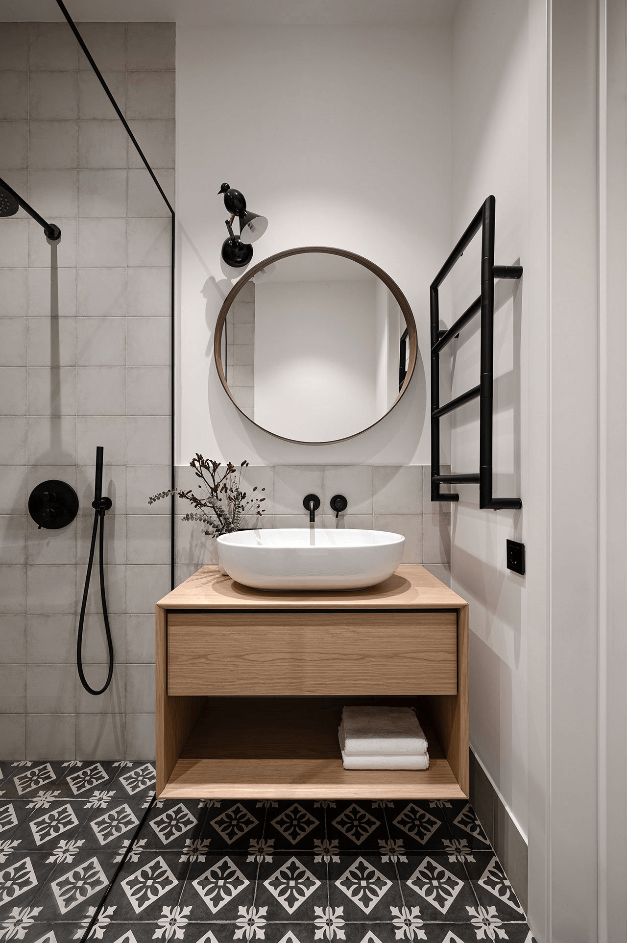 Une salle de bain avec meuble vasque bois et miroir rond